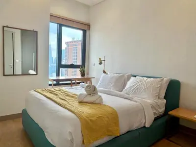 a teddy bear sitting on a bed in a bedroom at 1BR condo with Amazing KLCC View & Infinity Pool at Lalaport Bukit Bintang in Kuala Lumpur