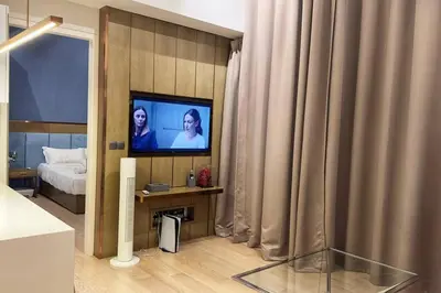 a room with a tv and a bed and curtains at Star Xtian Residence KLCC in Kuala Lumpur
