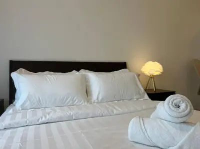 a bed with white pillows and a towel on it at The Robertson Bukit Bintang by DeUrban in Kuala Lumpur