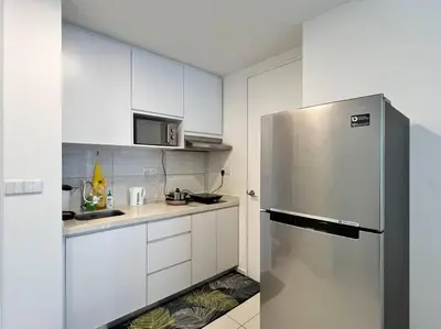 a kitchen with white cabinets and a stainless steel refrigerator at The Robertson Bukit Bintang by DeUrban in Kuala Lumpur