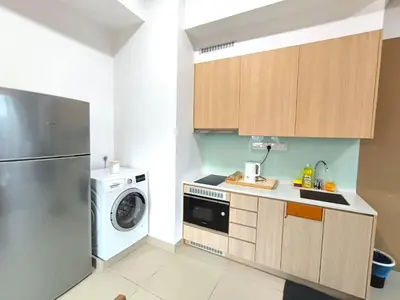 a kitchen with a washing machine and a washer at The Luxe Colony KLCC BY Infinitum in Kuala Lumpur