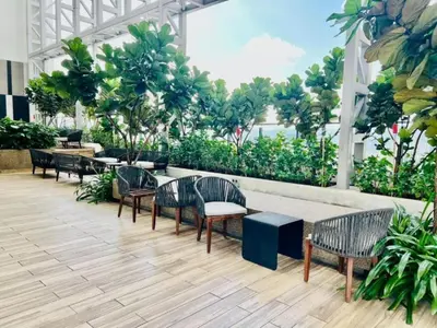 a lobby with tables and chairs and trees at The Luxe Colony KLCC BY Infinitum in Kuala Lumpur