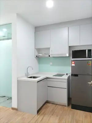 a kitchen with white cabinets and a stainless steel refrigerator at Riveria City KL Sentral by Jane in Kuala Lumpur