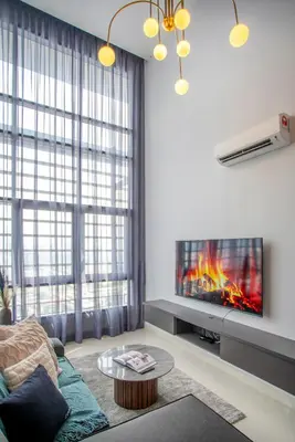 a living room with a couch and a tv at Novo Kuala Lumpur by Cobnb, Jalan Ampang in Kuala Lumpur