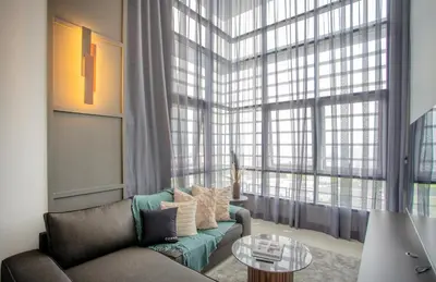 a living room with a couch and a large window at Novo Kuala Lumpur by Cobnb, Jalan Ampang in Kuala Lumpur
