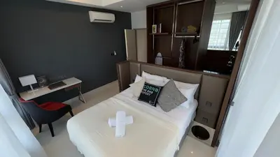 a bedroom with a bed with a cross on it at Novo Kuala Lumpur by Cobnb, Jalan Ampang in Kuala Lumpur