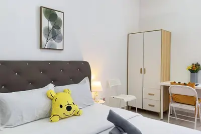 a stuffed winnie the pooh pillow sitting on a bed at Couple nest studio with KLCC view Balcony Trion A4309KL in Kuala Lumpur