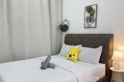 a yellow stuffed animal sitting on a bed at Couple nest studio with KLCC view Balcony Trion A4309KL in Kuala Lumpur