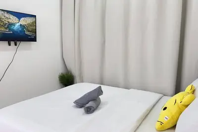 a white bed with two stuffed animals on it at Couple nest studio with KLCC view Balcony Trion A4309KL in Kuala Lumpur