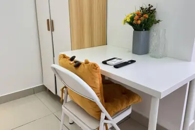 a room with a white desk with a chair and flowers at Couple nest studio with KLCC view Balcony Trion A4309KL in Kuala Lumpur