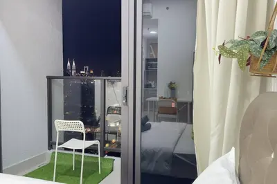 a room with a window with a chair and a bedroom at Couple nest studio with KLCC view Balcony Trion A4309KL in Kuala Lumpur