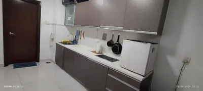 a kitchen with a white counter and a refrigerator at Infinity Pool Hostel in Kuala Lumpur