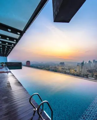 a swimming pool on top of a building with a city skyline at Infinity View KL Hostel in Kuala Lumpur