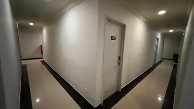 a hallway with white walls and a door in a building at Hotel AL Amin By Ahmed in Kuala Lumpur