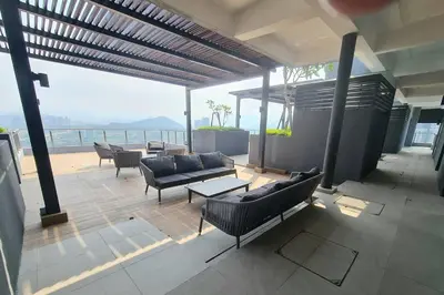 a patio with couches and tables and a view of the ocean at Neu Suites Studio 10mins to KLCC in Kuala Lumpur