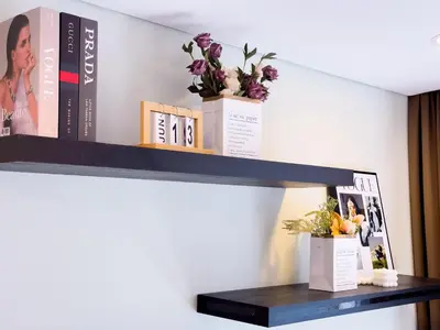 a black shelf with books and flowers on it at Sky Suite KLCC in Kuala Lumpur