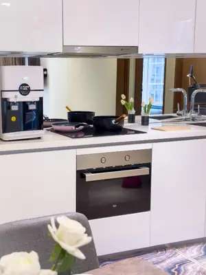 a white kitchen with a stove and a sink at Sky Suite KLCC in Kuala Lumpur