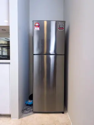 a stainless steel refrigerator in the corner of a kitchen at Sky Suite KLCC in Kuala Lumpur