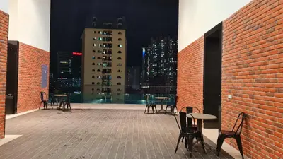 a patio with tables and chairs and a city skyline at Chambers Suites KLCC By City Homes in Kuala Lumpur
