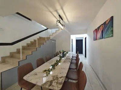 a dining room with a long table and chairs at Taman Duta KL Deluxe Villa by uBook in Kuala Lumpur