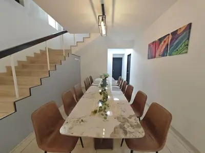 a dining room with a long table and chairs at Taman Duta KL Deluxe Villa by uBook in Kuala Lumpur