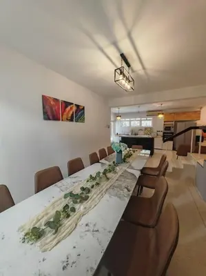 a large dining room with a long table and chairs at Taman Duta KL Deluxe Villa by uBook in Kuala Lumpur