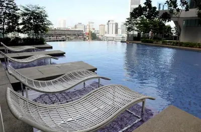 a group of chairs sitting next to a river at Pool World at Robertson Residence Kuala Lumpur in Kuala Lumpur