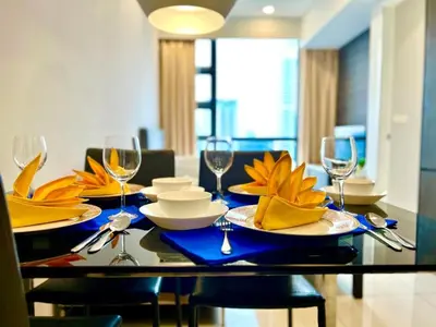 a dining room table with plates and wine glasses at Pool World at Robertson Residence Kuala Lumpur in Kuala Lumpur