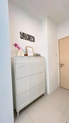 a white cabinet in a white room with flowers on it at Inara Homestay in Kuala Lumpur