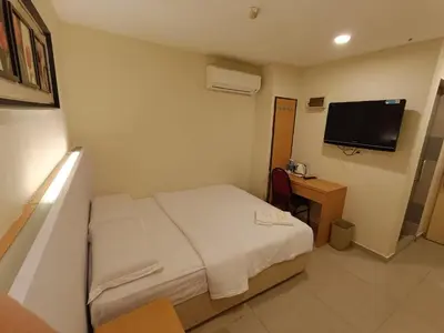 a hotel room with a bed and a television at South of The Clouds HOTEL KL Sentral \u5409\u9686\u5761\u5f69\u4e91\u4e4b\u5357\u9152\u5e97-\u4e2d\u592e\u8f66\u7ad9\u5e97 in Kuala Lumpur