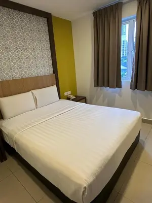 a large white bed in a room with a window at South of The Clouds HOTEL KL Sentral \u5409\u9686\u5761\u5f69\u4e91\u4e4b\u5357\u9152\u5e97-\u4e2d\u592e\u8f66\u7ad9\u5e97 in Kuala Lumpur