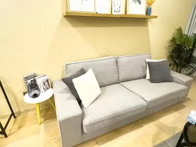 a gray couch with pillows in a living room at Family comfy 2BR at Star residence2 KLCC in Kuala Lumpur