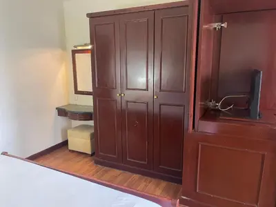 a bedroom with a wooden cabinet and a mirror at KL Elegant Apartment at Times Square in Kuala Lumpur