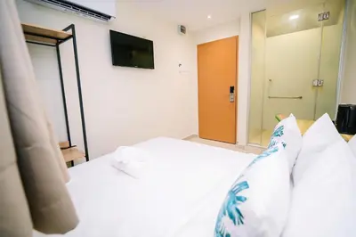 a bedroom with a white bed and a television at Swing & Pillows - Times Square, Bukit Bintang in Kuala Lumpur