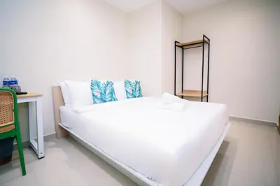 a white bed in a room with a mirror at Swing & Pillows - Times Square, Bukit Bintang in Kuala Lumpur