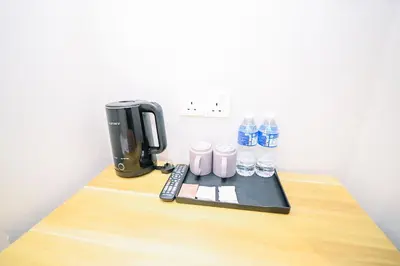 a coffee maker and water bottles on a desk at Swing & Pillows - Times Square, Bukit Bintang in Kuala Lumpur
