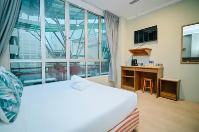 a hotel room with a bed and a large window at Swing & Pillows - Petaling Street Kuala Lumpur in Kuala Lumpur