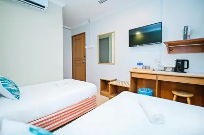 a hotel room with two beds and a sink at Swing & Pillows - Petaling Street Kuala Lumpur in Kuala Lumpur