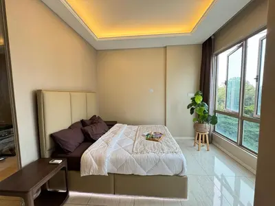 a bedroom with a bed and a table and windows at Dorsett Residence Sri Hartamas by Chengal with Bathtub, Rooftop Pool, KL City Centre, Round the Clock Security, Netflix, Youtube, Free Parking in Kuala Lumpur