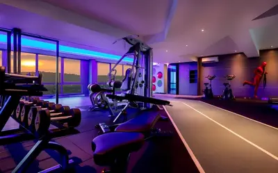 a gym with cardio equipment in a room with purple lighting at Dorsett Residence Sri Hartamas by Chengal with Bathtub, Rooftop Pool, KL City Centre, Round the Clock Security, Netflix, Youtube, Free Parking in Kuala Lumpur