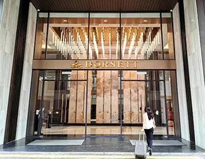 a woman walking in front of a department store at Dorsett Residence Sri Hartamas by Chengal with Bathtub, Rooftop Pool, KL City Centre, Round the Clock Security, Netflix, Youtube, Free Parking in Kuala Lumpur