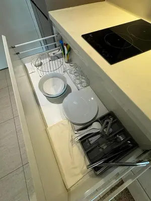 a cabinet with plates and utensils in a kitchen at Dorsett Residence Sri Hartamas by Chengal with Bathtub, Rooftop Pool, KL City Centre, Round the Clock Security, Netflix, Youtube, Free Parking in Kuala Lumpur