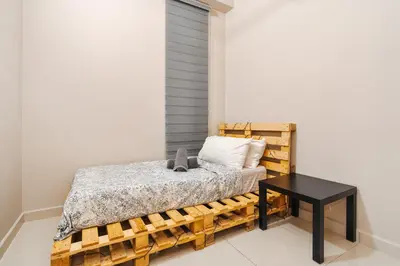a bedroom with a bed and a black table at Cozy Apartment with KLCC View & 1 Min to LRT Station in Kuala Lumpur