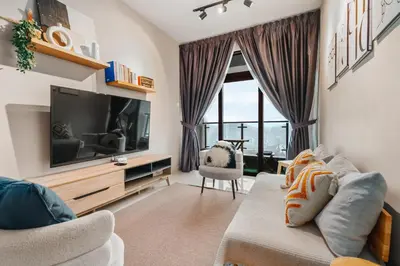 a living room with a couch and a tv at Cozy Apartment with KLCC View & 1 Min to LRT Station in Kuala Lumpur