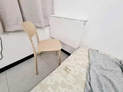 a chair sitting next to a bed in a room at Muji Tiny Studio Near KLCC in Kuala Lumpur