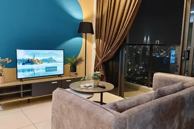 a living room with a couch and a flat screen tv at KLCC view 1BR service suite with Balcony Trion B5311 KL in Kuala Lumpur