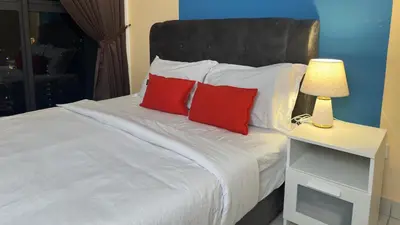 a bedroom with a white bed with red pillows at KLCC view 1BR service suite with Balcony Trion B5311 KL in Kuala Lumpur