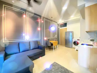 a living room with a blue couch and a kitchen at THE COLONY INFINITUM Sweet Home SR in Kuala Lumpur