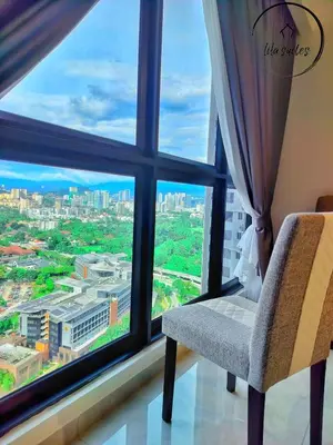 a chair sitting in front of a large window at Lila Suites Agile, Bukit Bintang ,KLCC in Kuala Lumpur