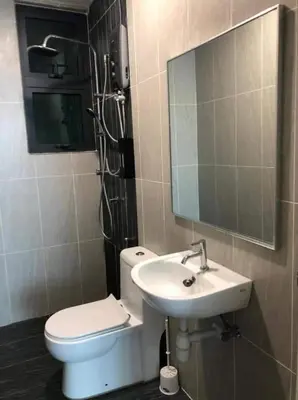 a bathroom with a toilet and a sink and a mirror at The suits klcc in Kuala Lumpur